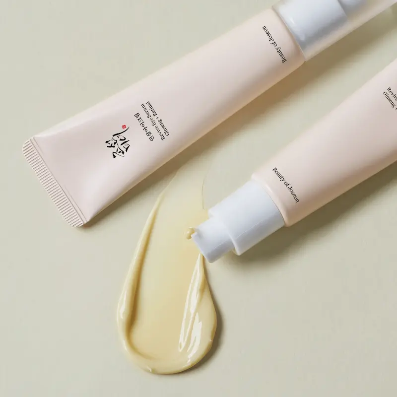 A close-up view of the silky, creamy yellow texture of the Beauty of Joseon Revive Eye Serum being dispensed from the tube