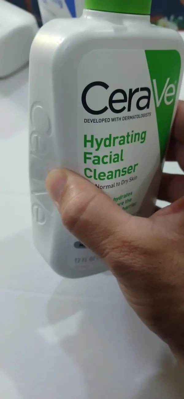 Original CeraVe Hydrating Facial Cleanser being pressed in, showing the soft, flexible plastic of a genuine bottle