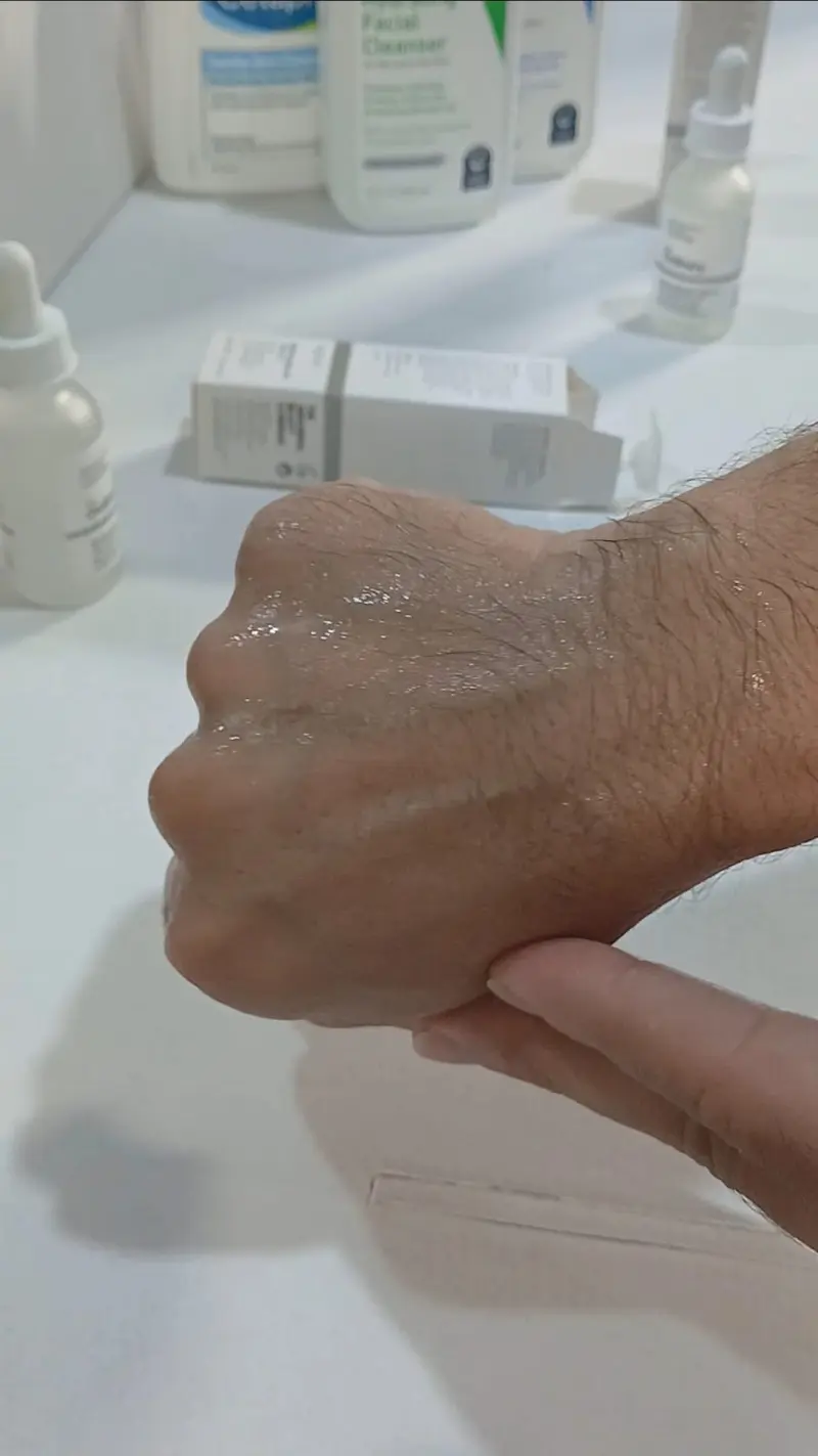 Fake The Ordinary Niacinamide serum rubbed on the back of the hand, showing a wet film with almost no foam